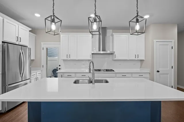 a kitchen with stainless steel appliances a counter top space cabinets and wooden floor