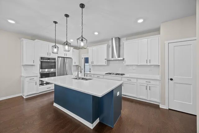a large kitchen with kitchen island a sink stove and white cabinets
