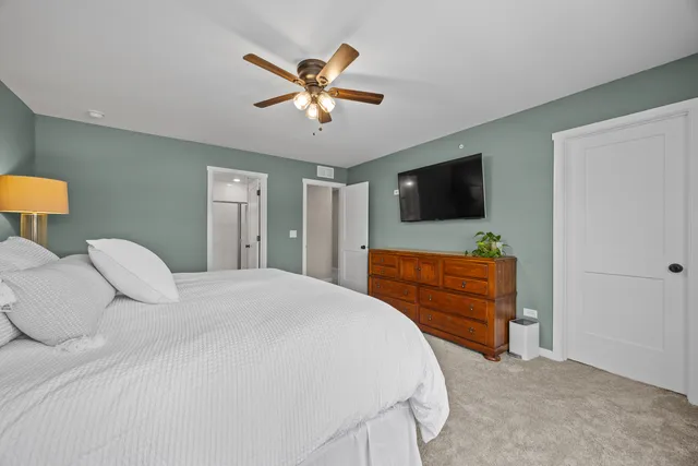 a spacious bedroom with a bed and a chandelier