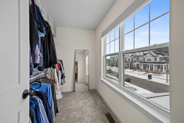 a view of walk in closet with clothes and shoes