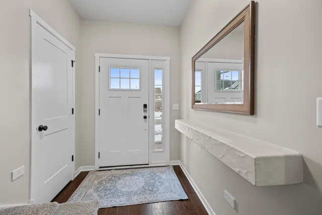 a view of an entryway with wooden floor and cabinet