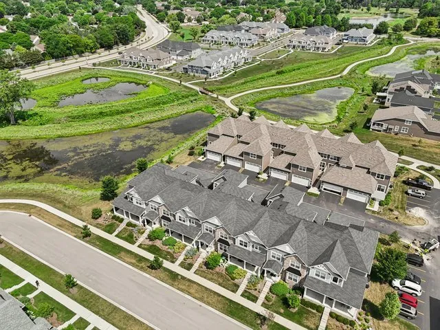 an aerial view of a residential houses with outdoor space and trees