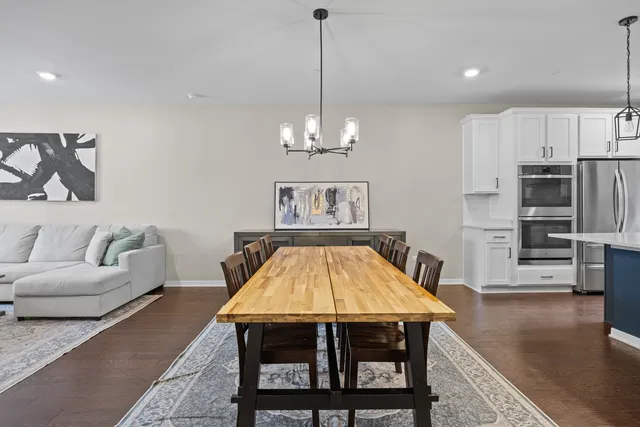 a living room with furniture a table and kitchen view