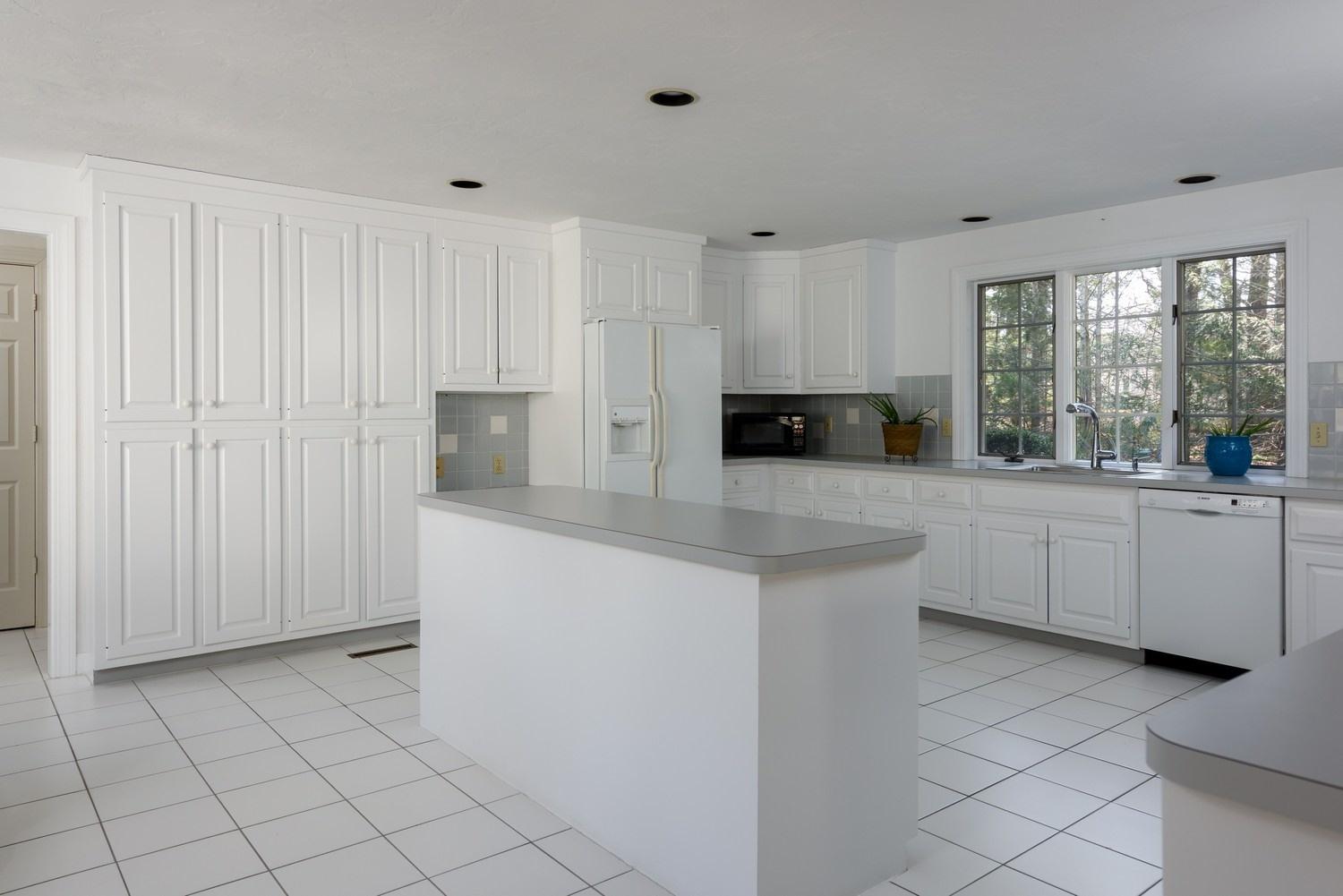 25 Oakdale Path Osterville, MA 02655 - Photo 11 of 21 a kitchen with white cabinets a sink and a stove