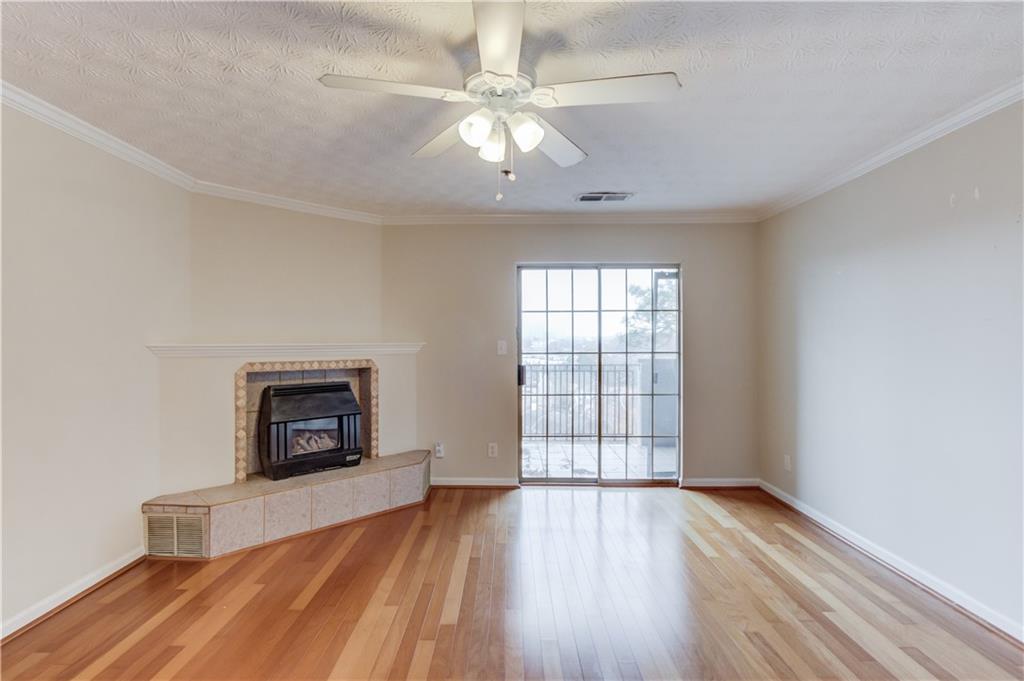 970 Sidney Marcus Boulevard Northeast, Unit 2403 Atlanta, GA 30324 - Photo 14 of 41 an empty room with windows a fireplace and wooden floor