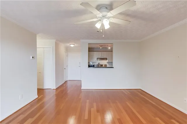 a view of a room with wooden floor and a ceiling fan