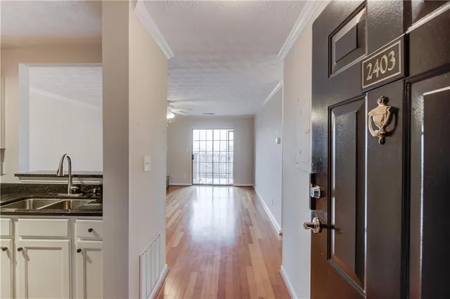 a view of a hallway with wooden floor and staircase