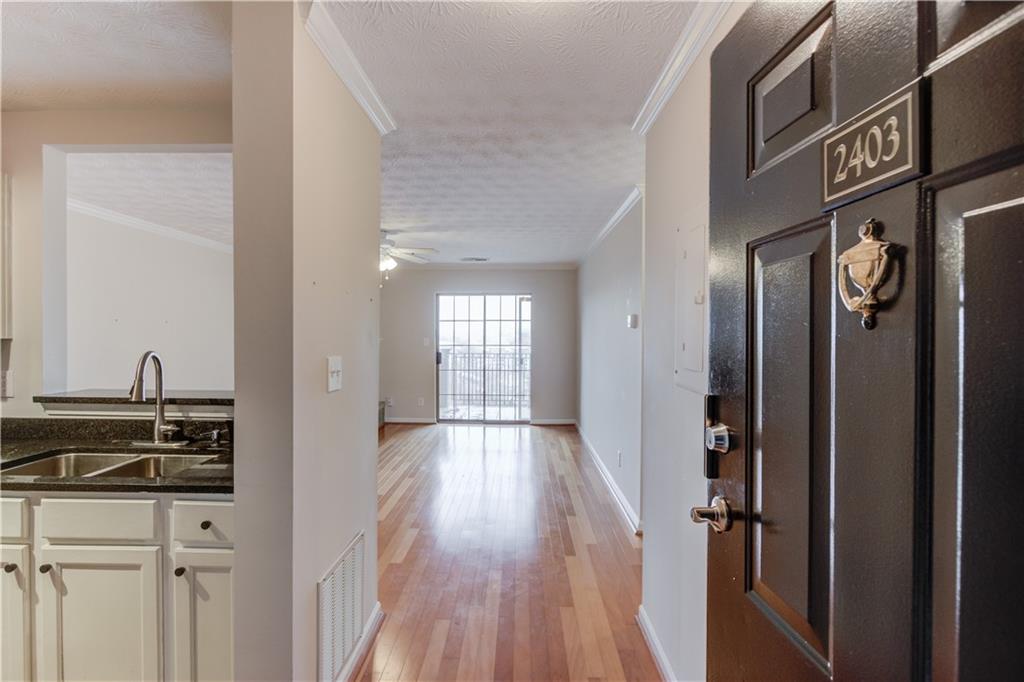 970 Sidney Marcus Boulevard Northeast, Unit 2403 Atlanta, GA 30324 - Photo 8 of 41 a view of a hallway with wooden floor and staircase