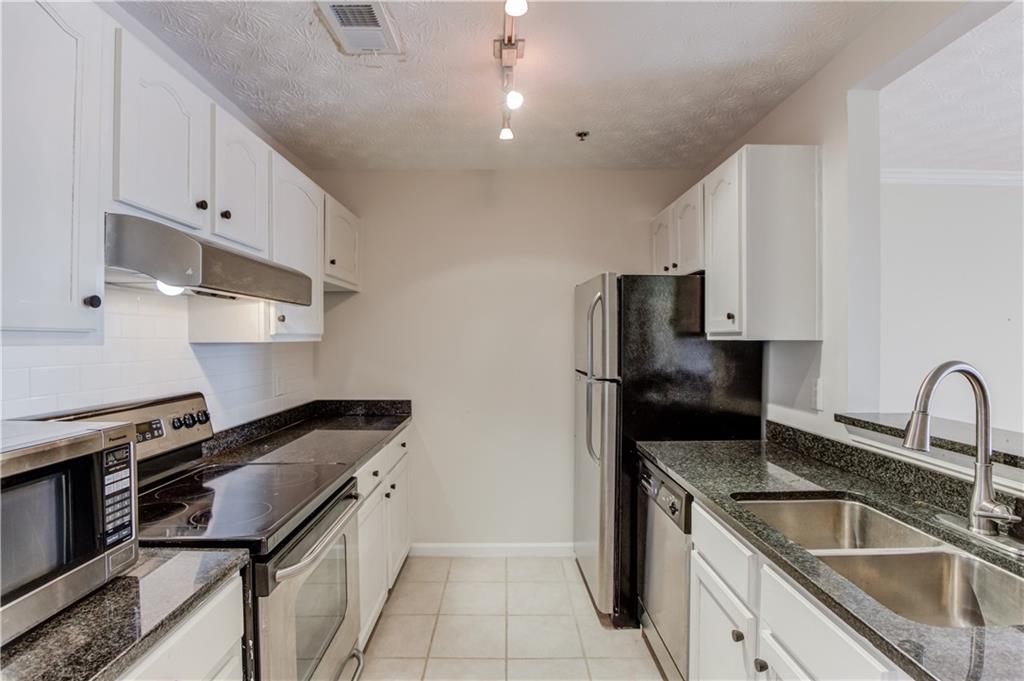 970 Sidney Marcus Boulevard Northeast, Unit 2403 Atlanta, GA 30324 - Photo 9 of 41 a kitchen that has a sink and a stove
