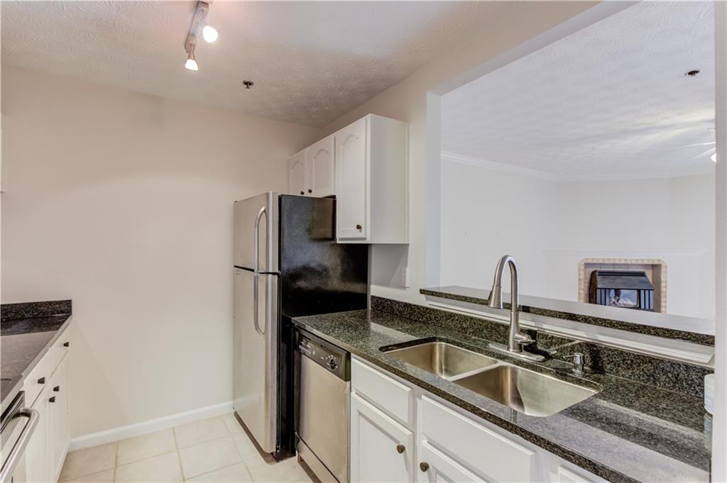 970 Sidney Marcus Boulevard Northeast, Unit 2403 Atlanta, GA 30324 - Photo 10 of 41 a kitchen with sink a refrigerator and cabinets