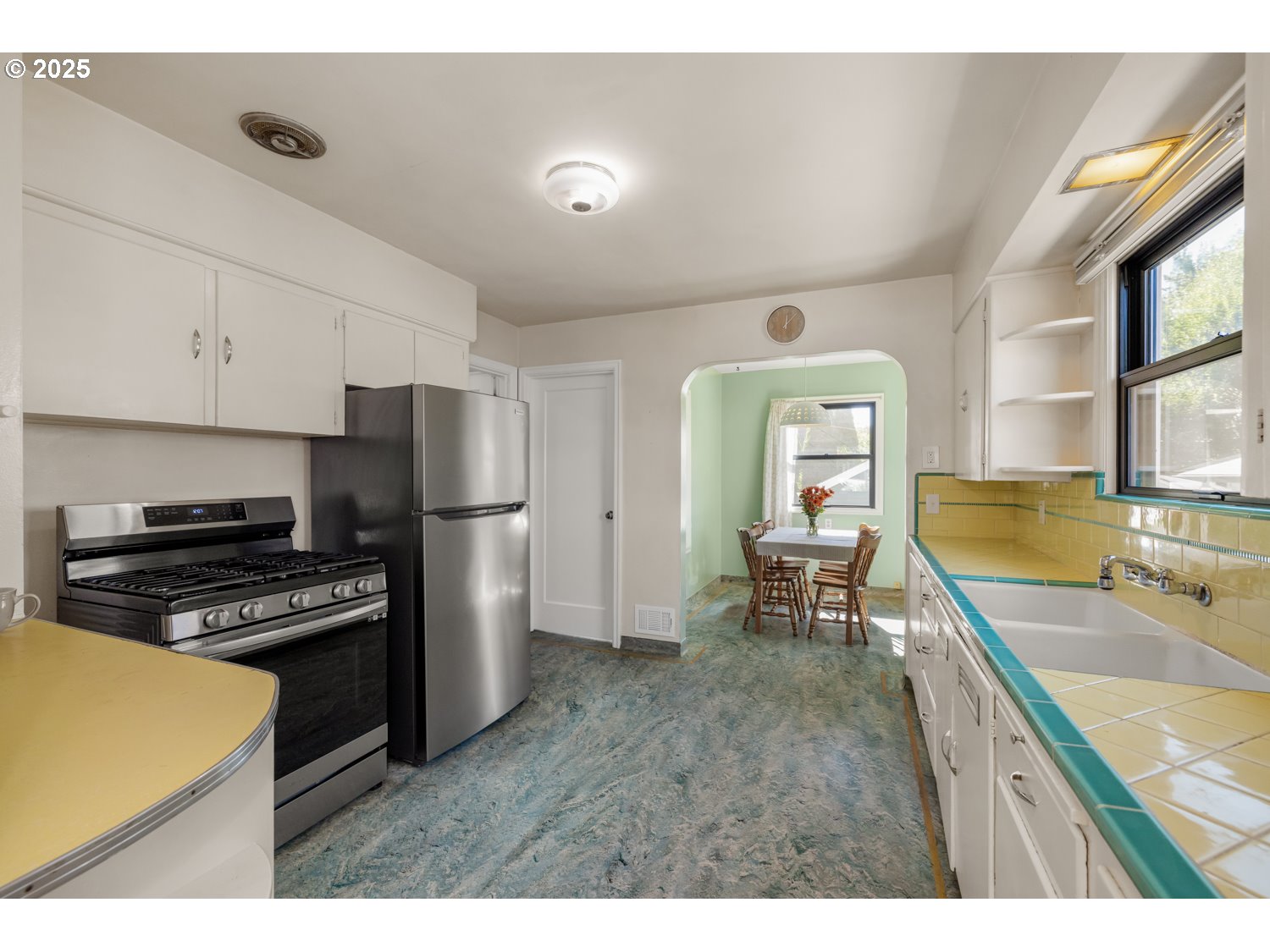 4016 Southeast Cora Street Portland, OR 97202 - Photo 9 of 30 a kitchen with a refrigerator a stove and a sink with wooden floor