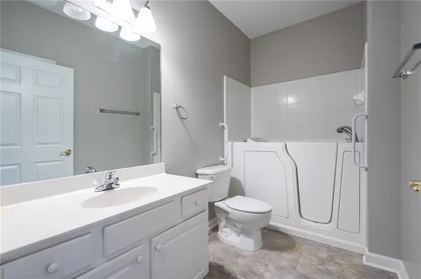 a bathroom with a granite countertop sink toilet and shower