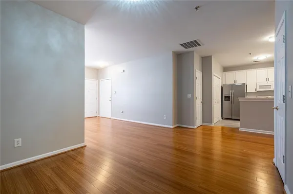 a view of a kitchen with a fridge and wooden floor