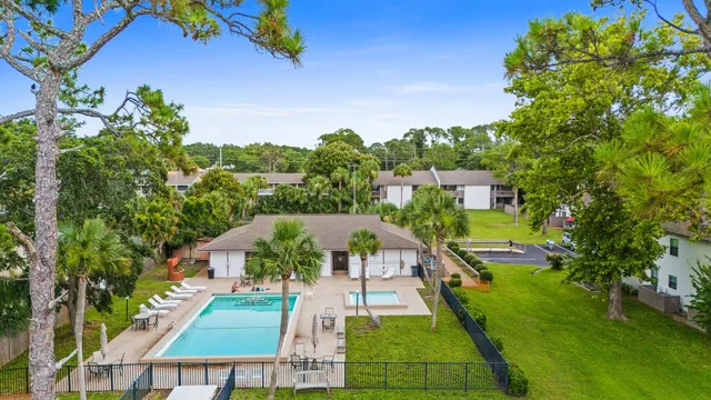 an aerial view of multiple houses with a yard