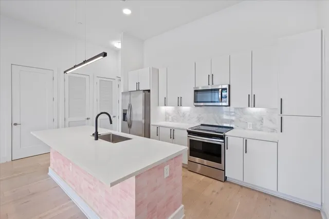 a kitchen with stainless steel appliances a sink stove and refrigerator