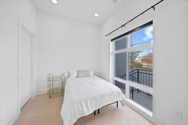 a bedroom with a bed and a large window