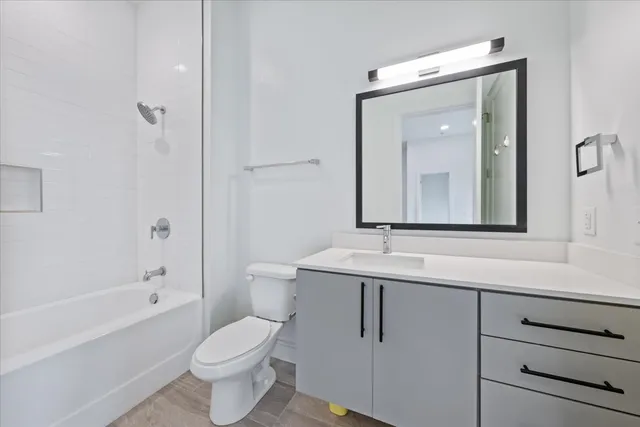 a bathroom with a toilet sink vanity tub and shower