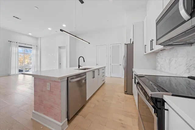 a kitchen with granite countertop a sink stove and refrigerator