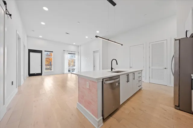 a large white kitchen with a sink a refrigerator and a stove
