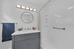 a bathroom with a sink vanity and a mirror