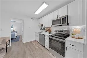 a kitchen with stainless steel appliances a stove sink microwave and cabinets