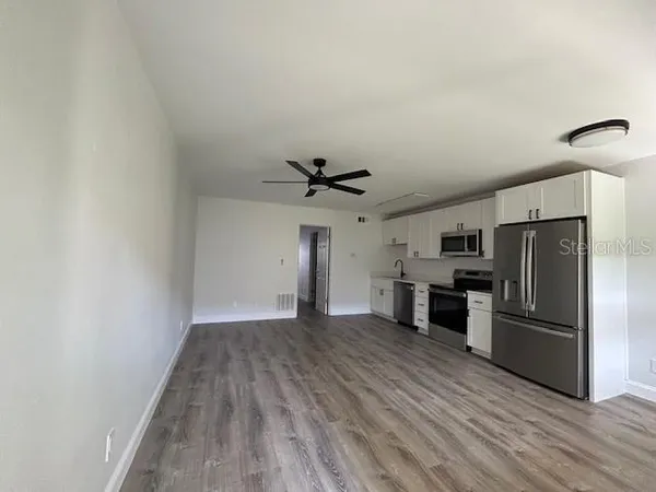 a view of a kitchen with a sink and a refrigerator