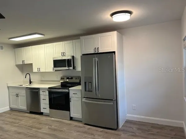 a kitchen with a sink stainless steel appliances and cabinets