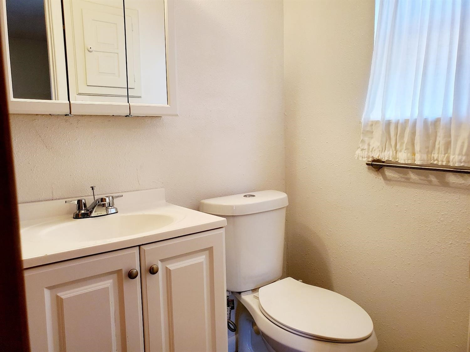 5419 46th Street Lubbock, TX 79414 - Photo 19 of 36 a bathroom with a sink a toilet and vanity