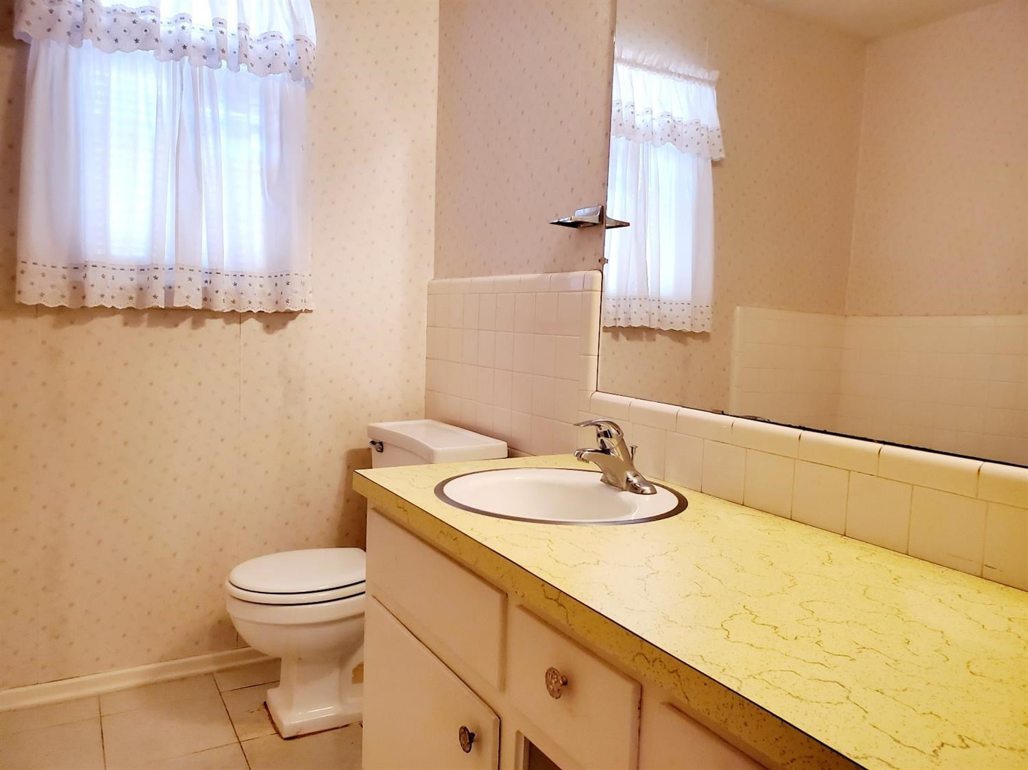 5419 46th Street Lubbock, TX 79414 - Photo 27 of 36 a bathroom with a granite countertop sink a toilet and a mirror