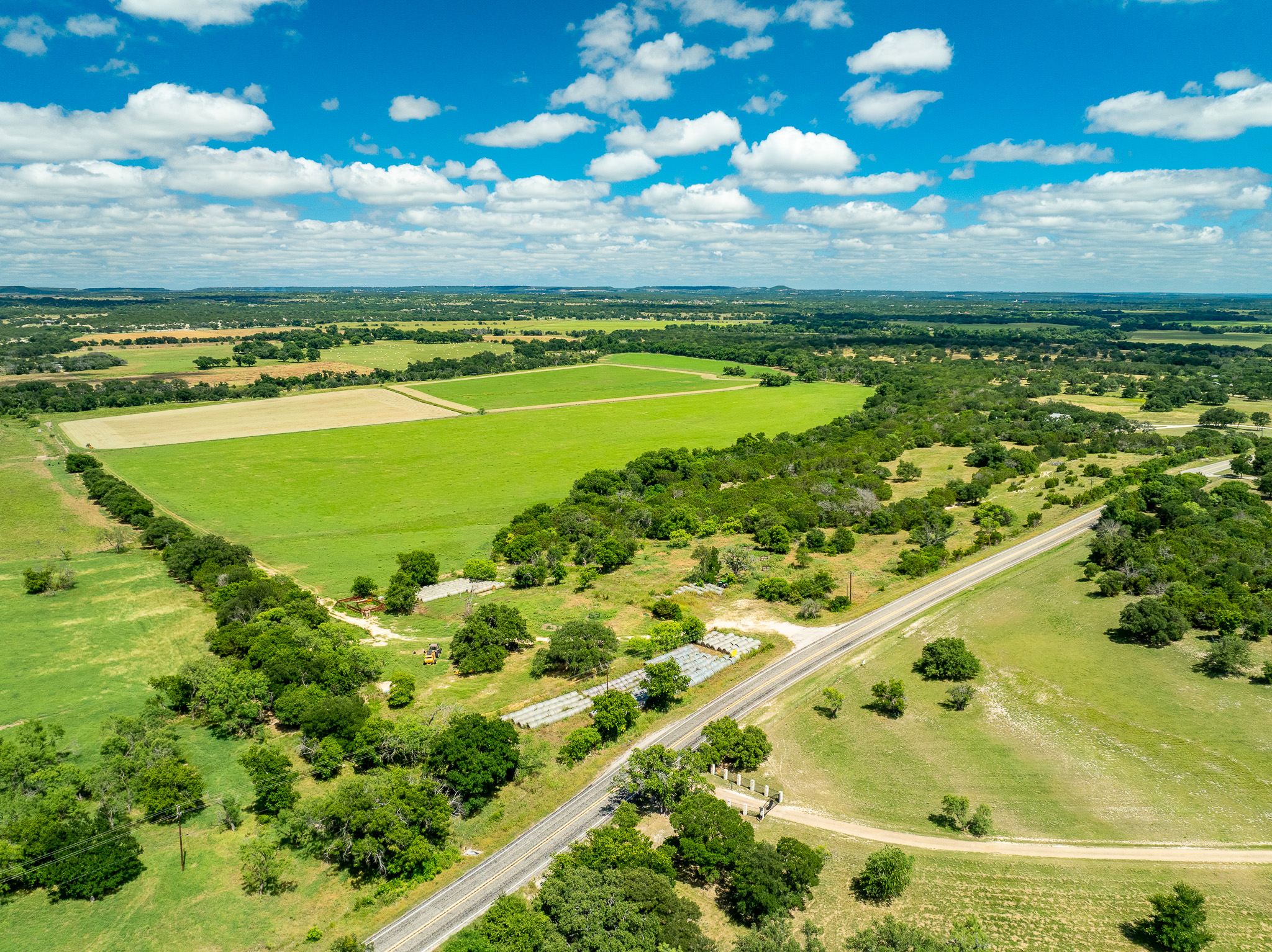 8044 580th Street East Kempner, TX 76539 - Photo 5 of 40 Vast green fields and scattered woodlands stretch under an open sky, offering abundant pastoral views.