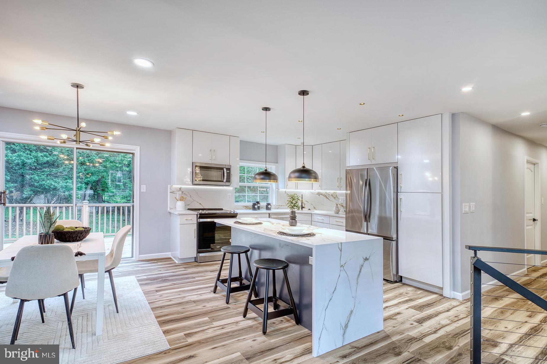 4108 Century Towne Road Randallstown, MD 21133 - Photo 15 of 51 a kitchen with stainless steel appliances a dining table chairs stove refrigerator and cabinets