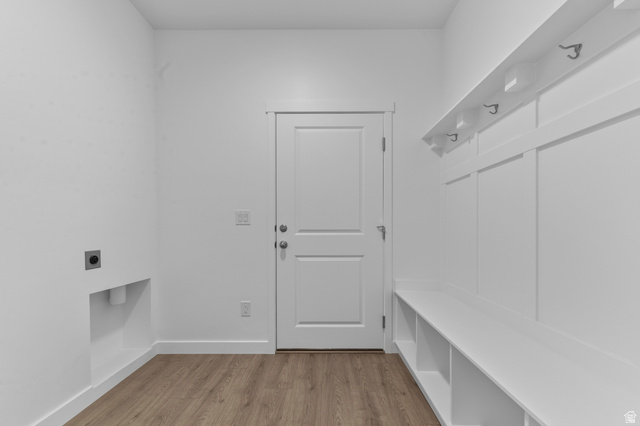 1338 West 2350 South, Unit 19 Perry, UT 84302 - Photo 10 of 14 Mudroom featuring wood-finish flooring, a white paneled door, and built-in white board-and-batten style storage with a bench, shelving, and coat hooks