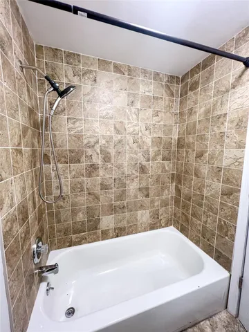 a bathroom with a bathtub and shower