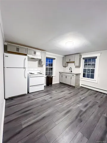 a view of kitchen with wooden floor and electronic appliances