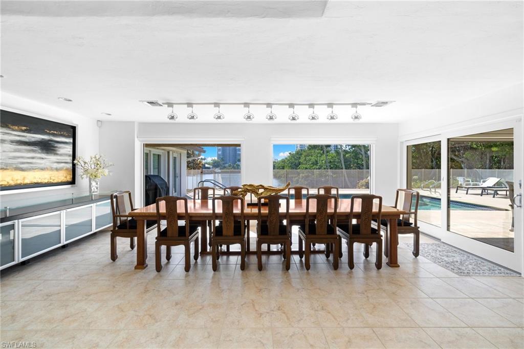 319 Pirates Bight Naples, FL 34103 - Photo 13 of 26 a large dining space with furniture window and wooden floor