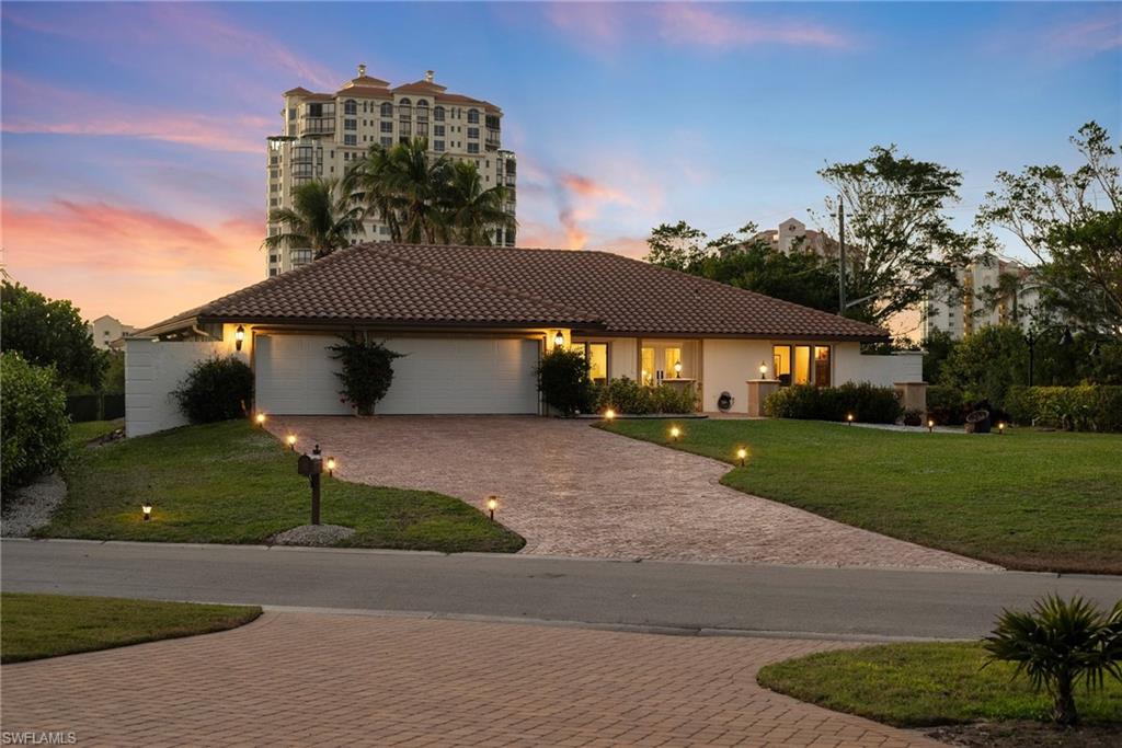 319 Pirates Bight Naples, FL 34103 - Photo 4 of 26 a front view of a house with a garden