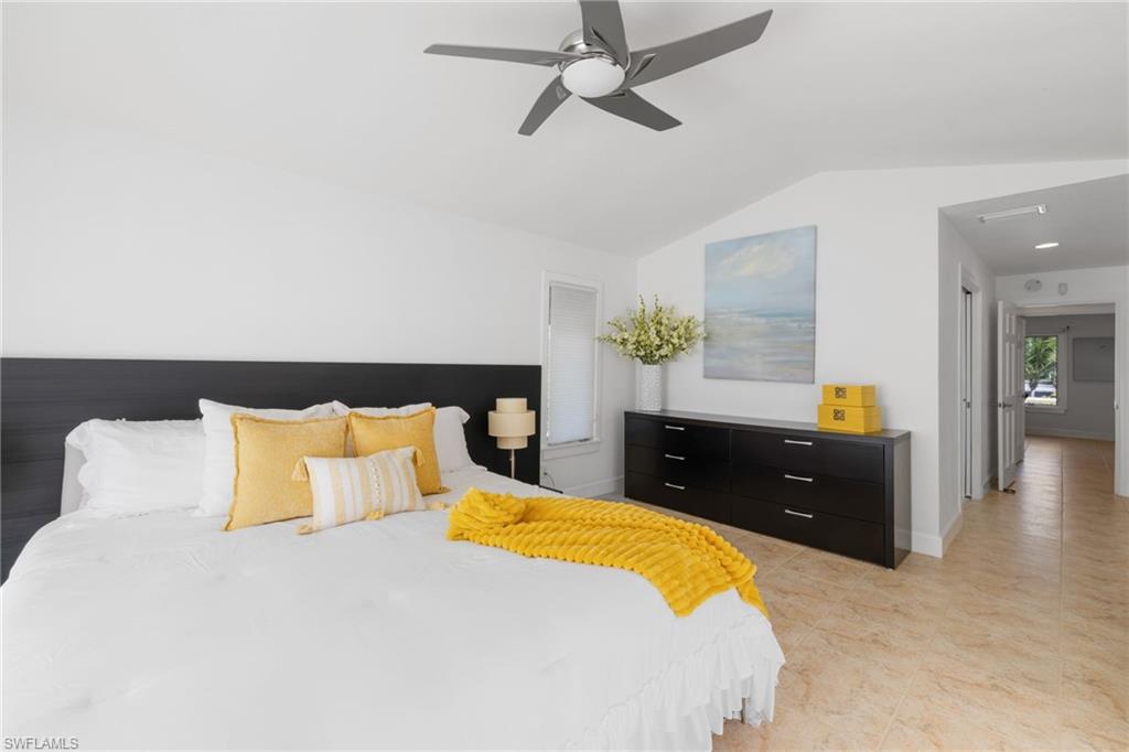 319 Pirates Bight Naples, FL 34103 - Photo 8 of 26 a bedroom with a bed and a chandelier