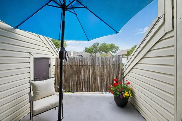 a balcony with furniture and an umbrella