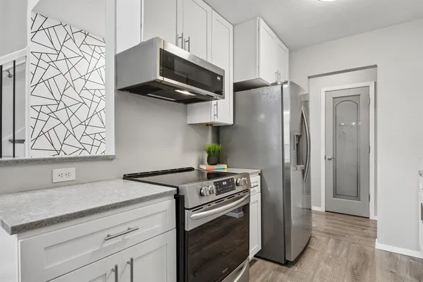 a kitchen with stainless steel appliances white cabinets and a stove