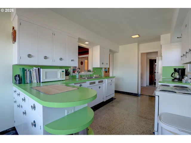 a kitchen with kitchen island granite countertop white cabinets and white appliances