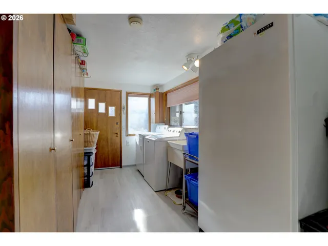 a room with stainless steel appliances kitchen island granite countertop furniture and a refrigerator