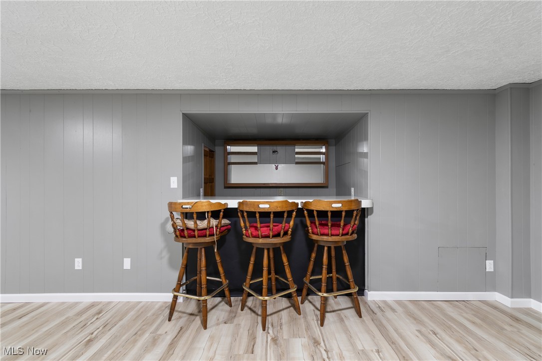 3143 Ethan Allen Road Barberton, OH 44203 - Photo 24 of 37 Indoor dry bar with a textured ceiling, wood finished floors, and wood walls