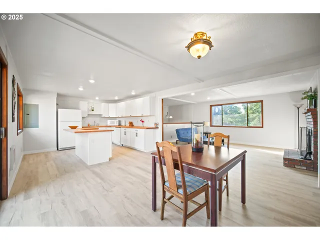 a living room with furniture and a dining table with wooden floor
