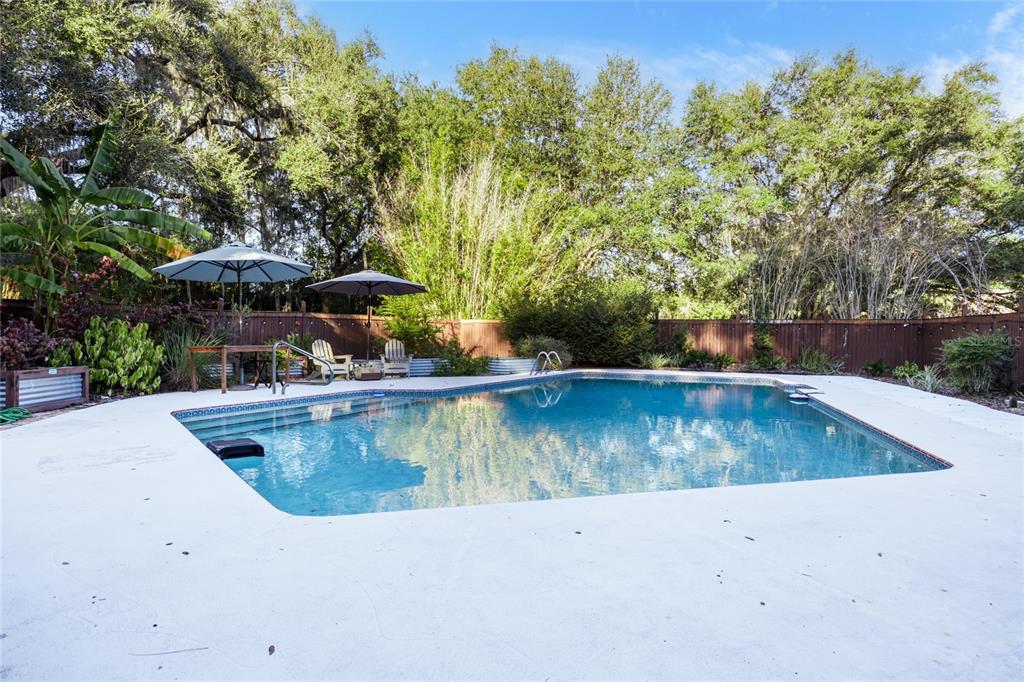 2006 Northwest 104th Way Gainesville, FL 32606 - Photo 62 of 71 a view of a swimming pool with a yard and plants