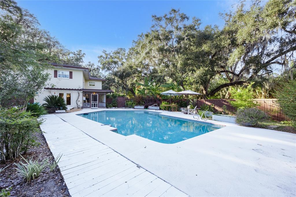 2006 Northwest 104th Way Gainesville, FL 32606 - Photo 63 of 71 a view of a house with pool fire pit and trees around