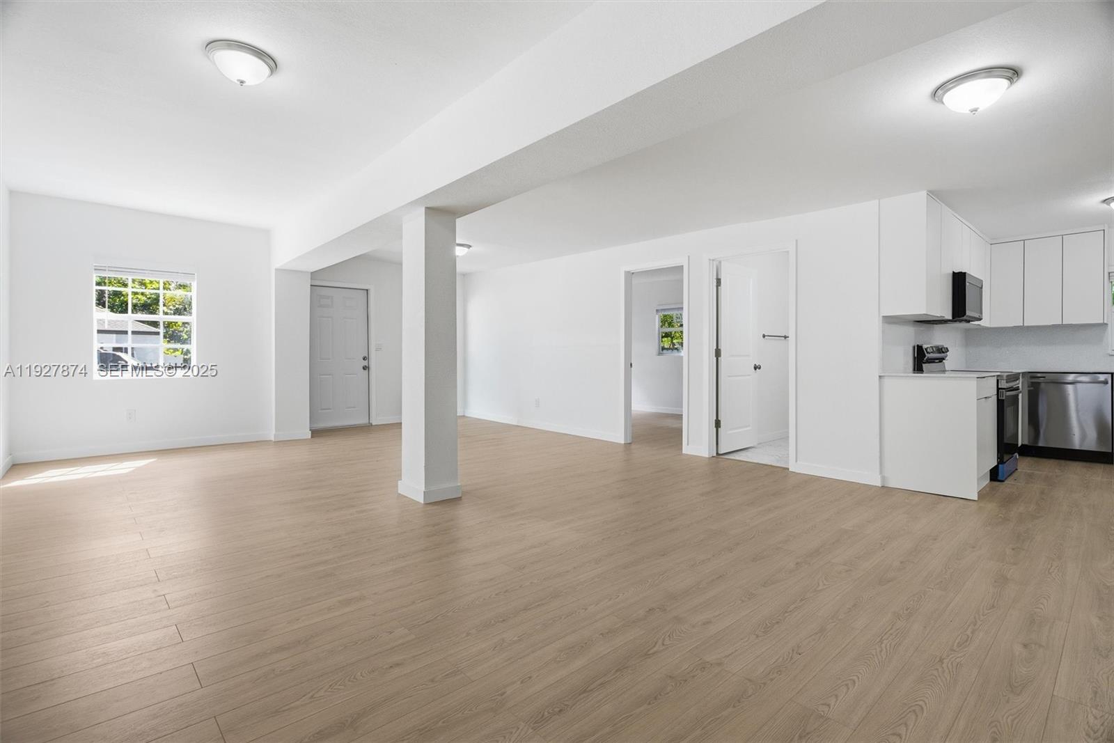 465 Northeast 165th Street, Unit 465 Miami, FL 33162 - Photo 5 of 15 a view of empty room with kitchen and window
