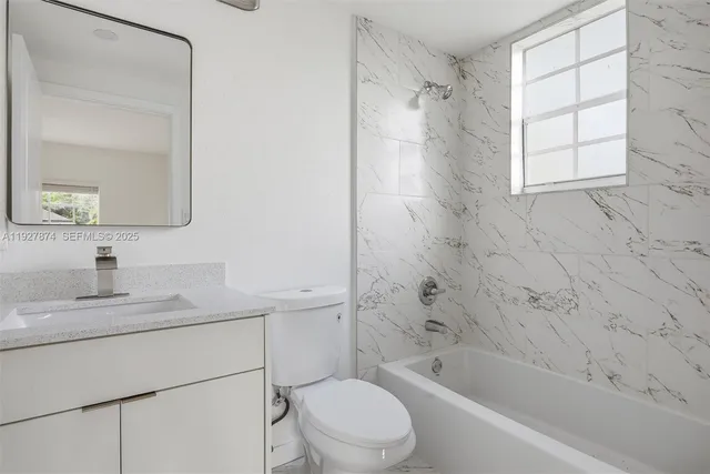 a bathroom with a bathtub toilet sink vanity and mirror