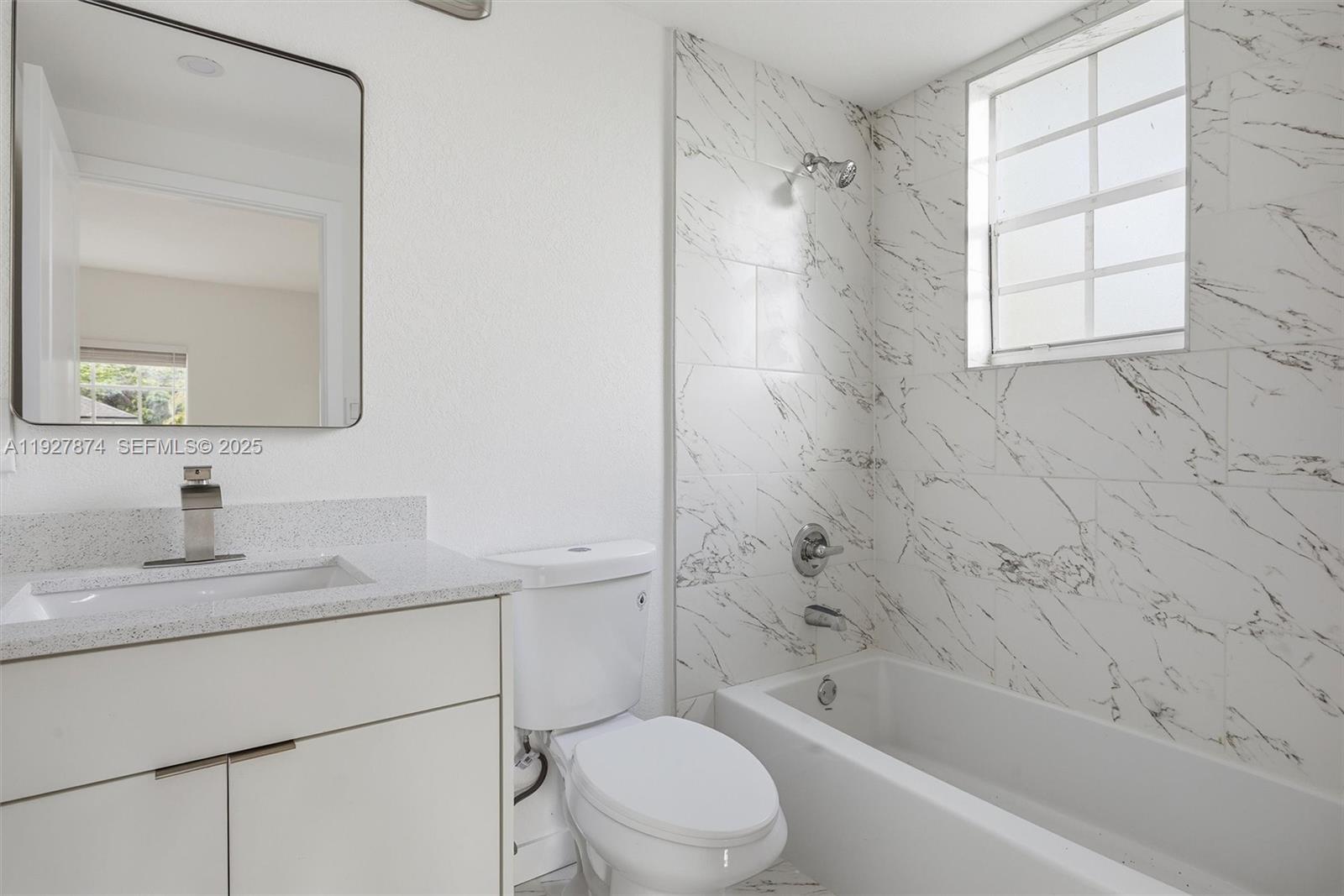 465 Northeast 165th Street, Unit 465 Miami, FL 33162 - Photo 6 of 15 a bathroom with a bathtub toilet sink vanity and mirror