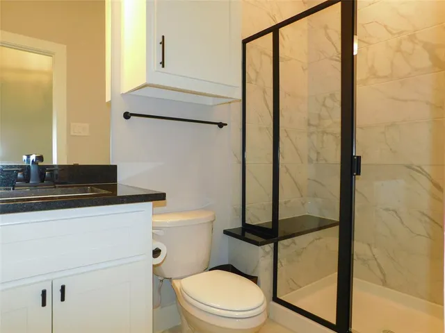a bathroom with a toilet a sink and shower