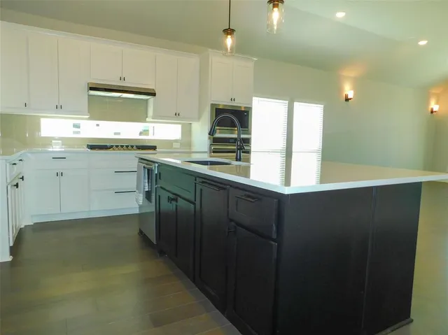 a kitchen with sink cabinets and appliances